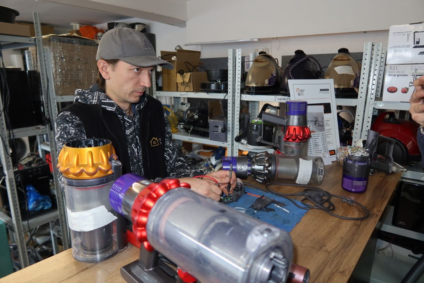 Мастер ремонтирует аккумуляторный пылесос Dyson