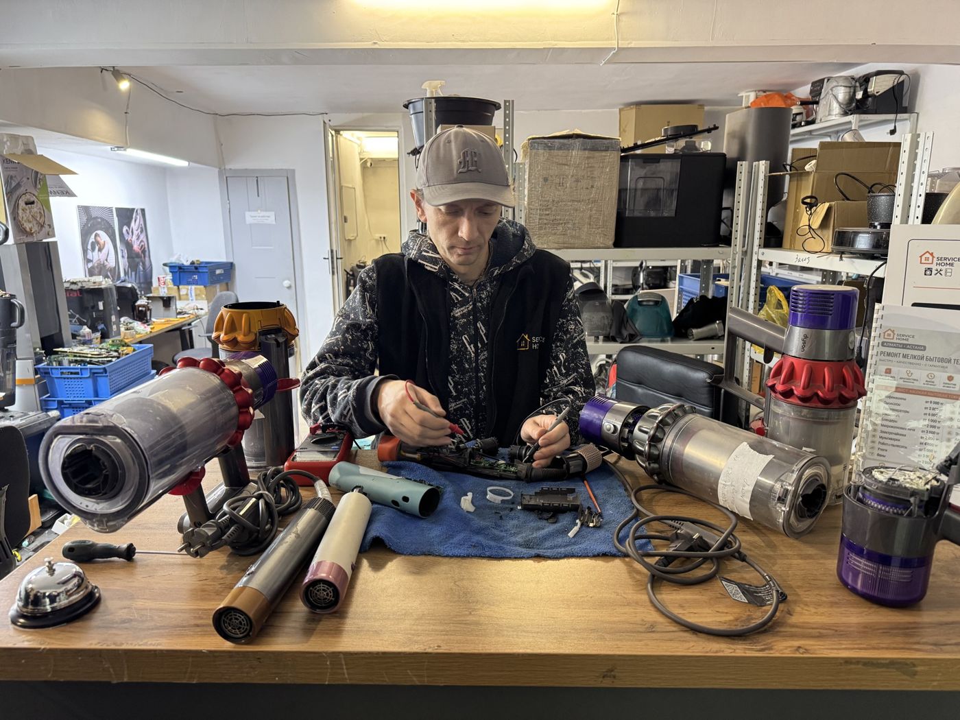 Разобранные пылесосы Dyson на столе мастера
