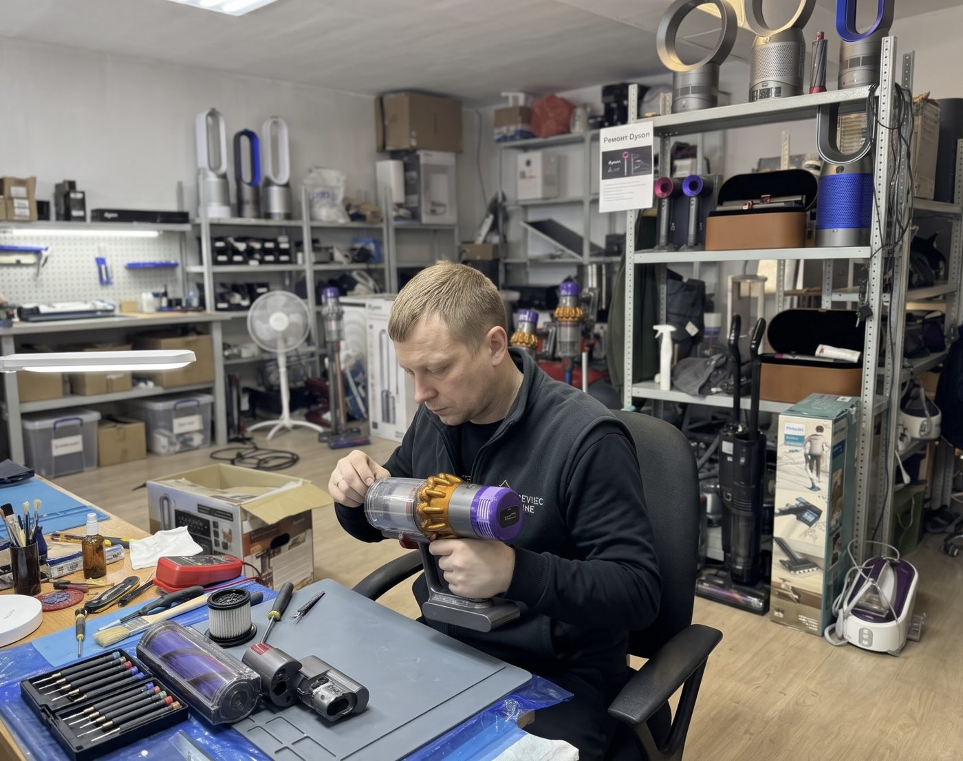 Мастер ремонтирует пылесос Dyson в сервисном центре